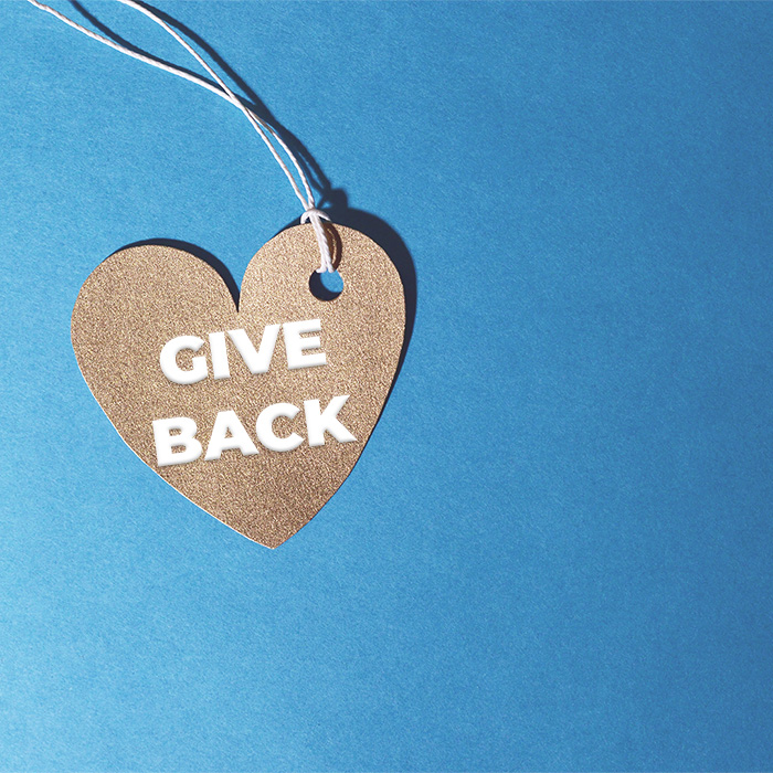 Heart shaped pendant inscribed with the phrase 'give back'